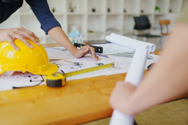 istock engineers discuss building on blueprint drawing, design building Project in office. 1796203600