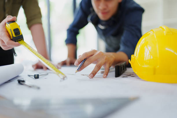 istock multi ethnic engineer brainstorming and measuring for cost estimating on blueprint and floor plan drawings about design architectural and engineering for houses and buildings 1796205193