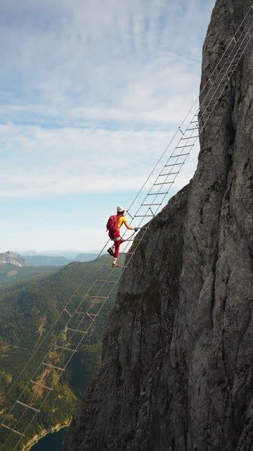 Woman climbing the ladder on via ferrata in Austria