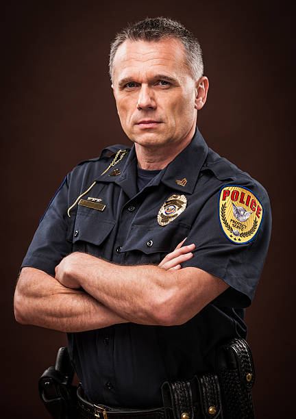 Law Enforcement Officer Portrait An authentic police officer in dark, moody lighting. macho photos stock pictures, royalty-free photos & images