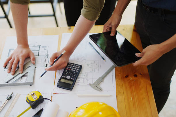 istock multi ethnic engineer brainstorming and measuring for cost estimating on paperworks and floor plan drawings about design architectural and engineering for houses and buildings 1796207855