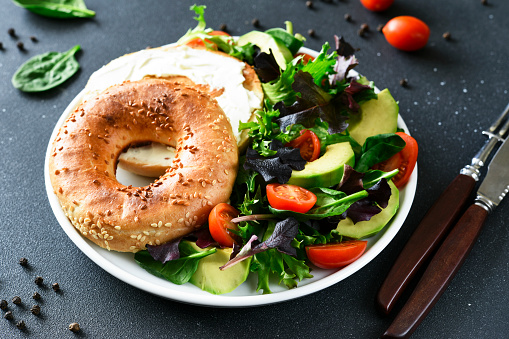Bagel with cream cheese and salad for breakfast