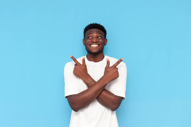 istock young guy african american in white t-shirt chooses from two options and thinks on blue isolated background 1796245409