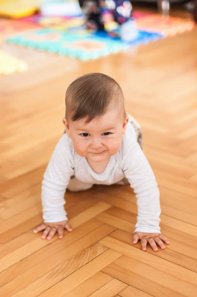 istock Cute baby boy crawls on the home floor. Front view 1796268571