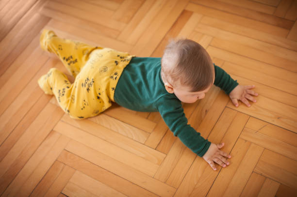 istock Cute baby boy crawls on the home floor. Top view 1796270153