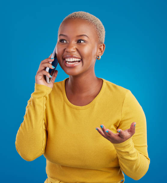 istock Phone call, excited and black woman talking in studio for social network, connection and conversation. Communication mockup, smartphone and surprised girl speaking, smile and chat on blue background 1796277110