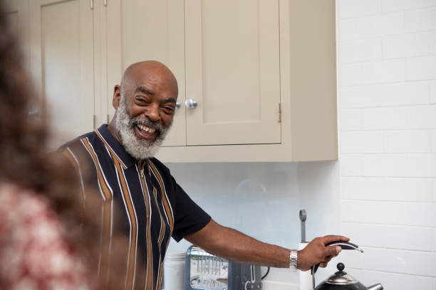 istock Smiling man making a hot drink in the kitchen at home 1796291196