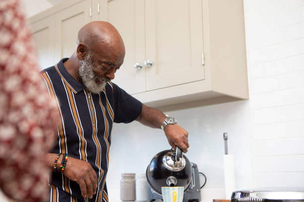 istock Smiling man making a hot drink in the kitchen at home 1796291198