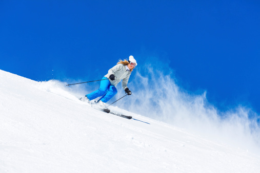 Mid adult women snow skier skiing on sunny ski resorts