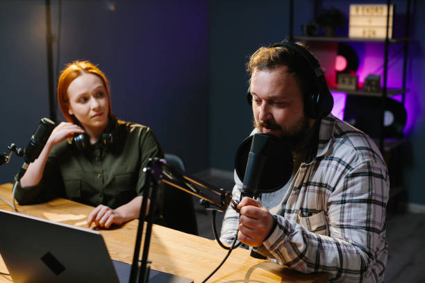 istock two radio hosts in headphones laughing while recording podcast in studio together 1796295626