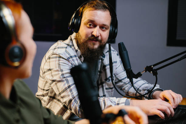 istock two radio hosts in headphones laughing while recording podcast in studio together 1796295654
