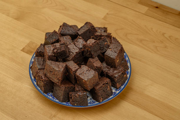 Chocolate brownie cake cut into pieces on a plate isolated closeup