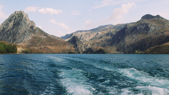 Sailing a boat on a beautiful lake among the mountains. 4K