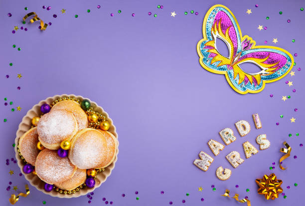 istock Mardi Gras King Cake Doughnuts or Donuts, Carnival Masks on Purple Background. 1796323503
