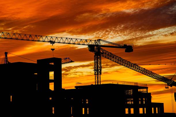 istock Silhouettes of construction cranes against a vibrant sunset sky 1796330475