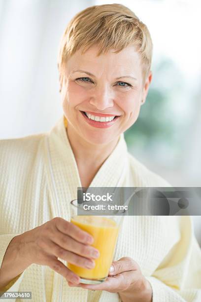 Happy Woman Holding Glass Of Juice Stock Photo - Download Image Now - Drinking Glass, Mature Women, Short Hair