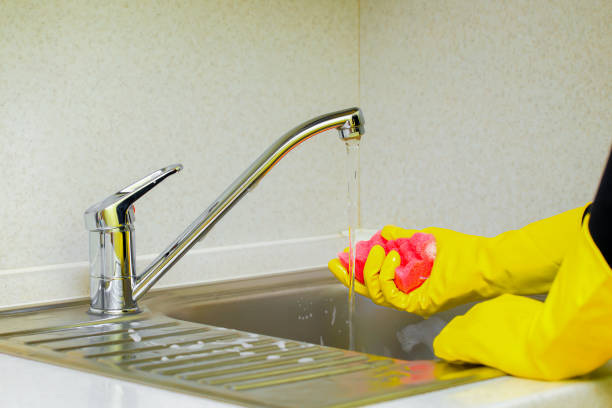 istock woman wets a sponge while cleaning the kitchen. 1796351074
