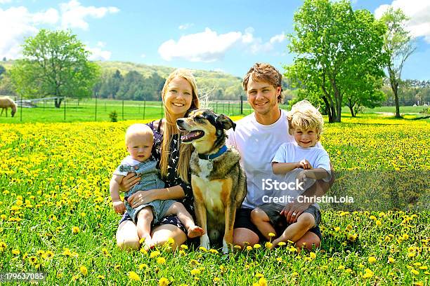 Foto de Família Feliz Sentado No Campo De Dentedeleão e mais fotos de stock de Família - Família, Fazenda, Animal