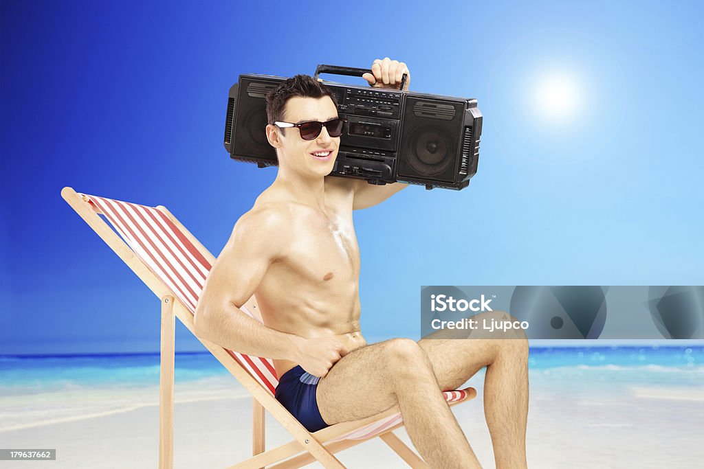 Bel homme assis sur une chaise avec des boombox - Photo de Adulte libre de droits