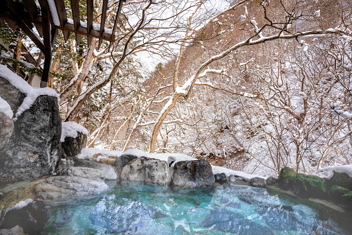 Japanese Hot Springs Onsen Natural Bath The mountain background is covered with a lot of snow. In winter in Japan