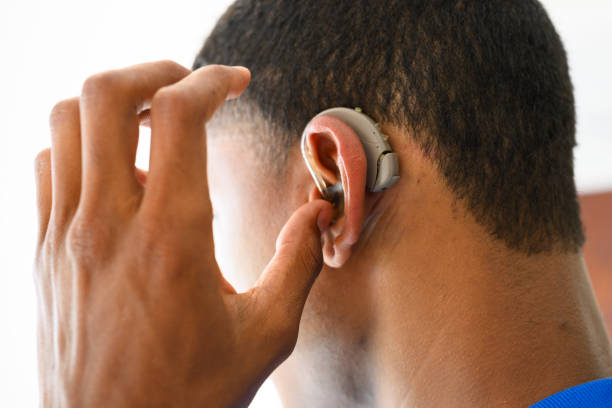 istock Close up side view young man putting hearing aid in ear 1796389172