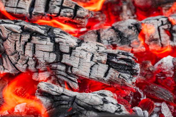 istock Burning red fire and smoldering charcoal close-up, selective focus, cracks 1796389201