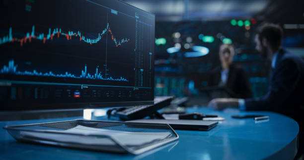 istock Close Up on a Computer Screen with Real-Time Stock Market Analytics, Graphs and Reports. Stock Exchange Software Template. Brokers Discussing Financial and Business Opportunities in the Background 1796395282