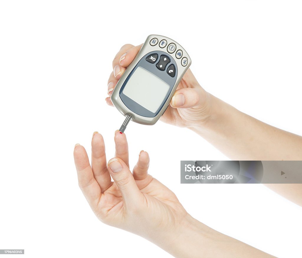 Diabetes patient measuring glucose level blood test Diabetes patient measuring glucose level blood test using mini glucometer and small drop of blood from finger and test strips on a white background Blood Stock Photo