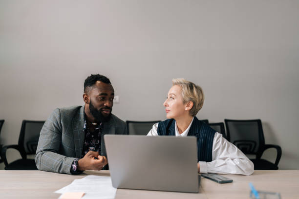 istock Focused middle-aged female leader helping new black worker with computer corporate software application in office. Motivated diverse employees developing 1796406086