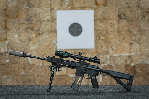Rifle with digital night vision device and silencer in a shooting range. High quality photo