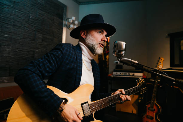 istock A musician is playing guitar and singing in a professional recording studio 1796413743