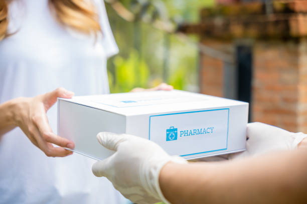 Sick Asian young woman receive medicine first aid pharmacy box from hospital delivery service Delivery man give medicine drug to patient female at home, Sick Asian young woman receive medication first aid pharmacy box from hospital delivery service, healthcare medicine online concept thai door stock pictures, royalty-free photos & images