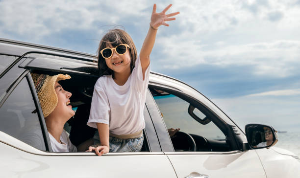 Asian mother father and children smiling sitting in compact white car looking out windows Happy family day. Asian mother father and children smiling sitting in compact white car looking out windows, Summer at the beach, Car insurance, Family holiday vacation travel, road trip concept happy car asian stock pictures, royalty-free photos & images