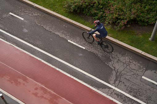 Man riding on bicycle on a bike path in the city. View from above. Concept of healthy lifestyle and riding bicycling on city.
