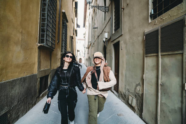 Two friends are running together in an ancient alley Two friends are running together in an ancient alley. They are wearing fashionable clothes. tuscany running stock pictures, royalty-free photos & images