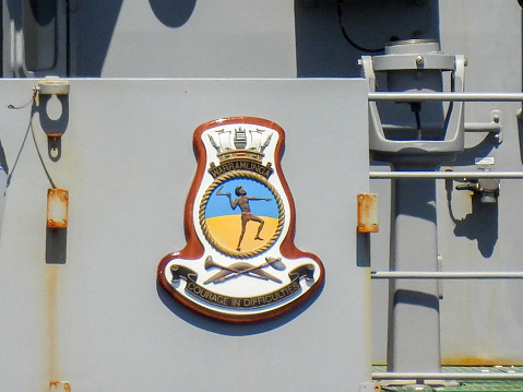 The ship's badge affixed next to the bridge of HMAS Warramunga, an Anzac Class frigate of the Royal Australian Navy.  The ship's motto is \