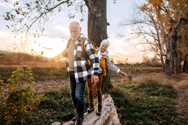 istock Senior couple walking on a tree log in forest 1796497910