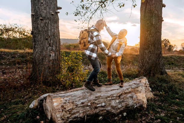 istock Senior couple walking on a tree log in forest 1796497931