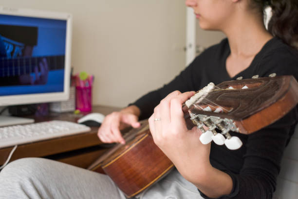 istock Young Girl watching online guitar lesson on computer. 1796506487