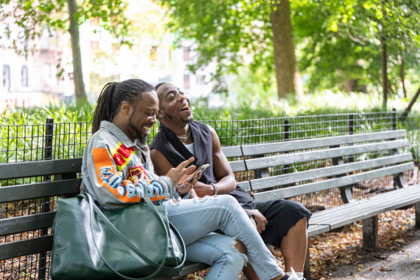 istock Friends relaxing on bench in public park 1796515688