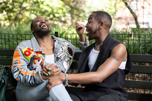istock Black couple holding hands and laughing on park bench 1796516204