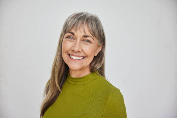 istock Mature woman smiling while standing in front of a gray background 1796522712