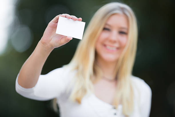 istock blond girl holding white card 179652846