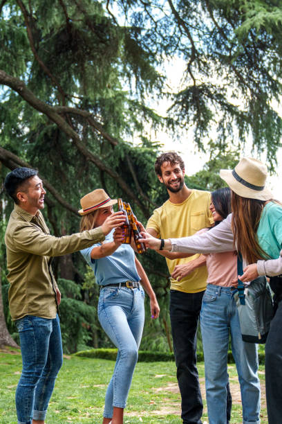 istock Friends Toasting with Beer Bottles at a Sunny Park Gathering 1796529606