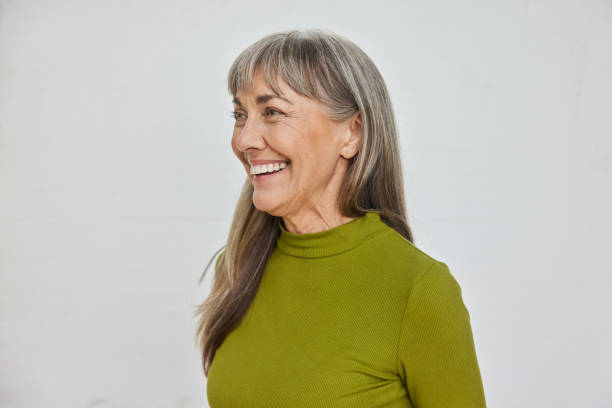 istock Mature woman smiling while standing against a gray background 1796533330
