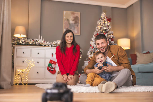 istock Father teaching son to use remote controlled car while spending Christmas day at home 1796535441
