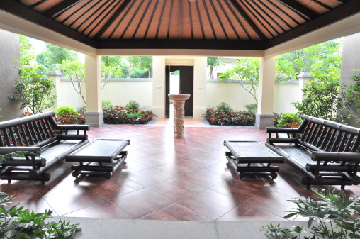 Wooden table and chairs in tropical Balinese styled courtyard.