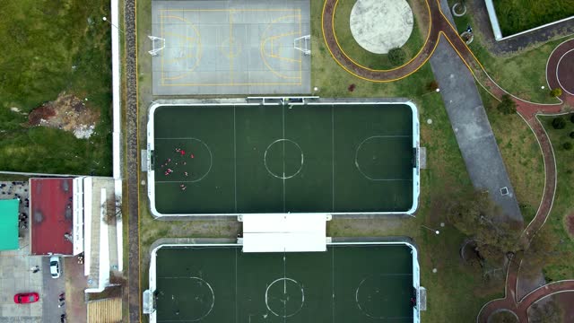 Aerial overhead shot of a synthetic grass 5-a-side soccer field with one of the areas being used for training.