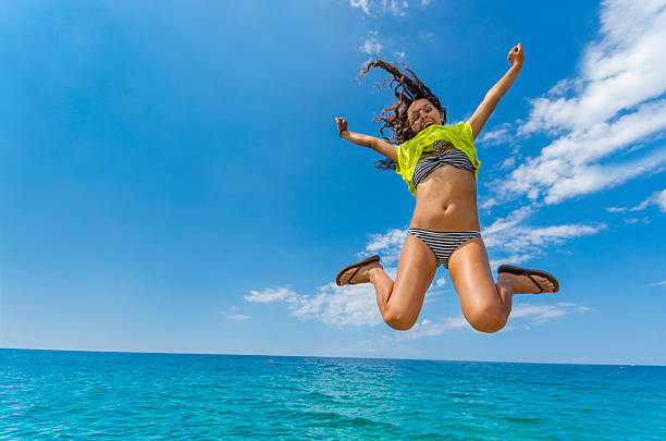 increíble verano teen jump sobre ocean blue water horizon. - one woman only beautiful lifestyle handcarves fotografías e imágenes de stock