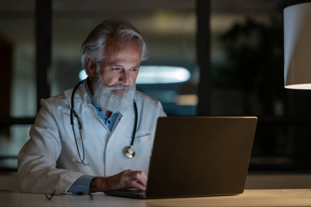 istock A night-shift doctor examines a case on a laptop in a darkened office 1796597238